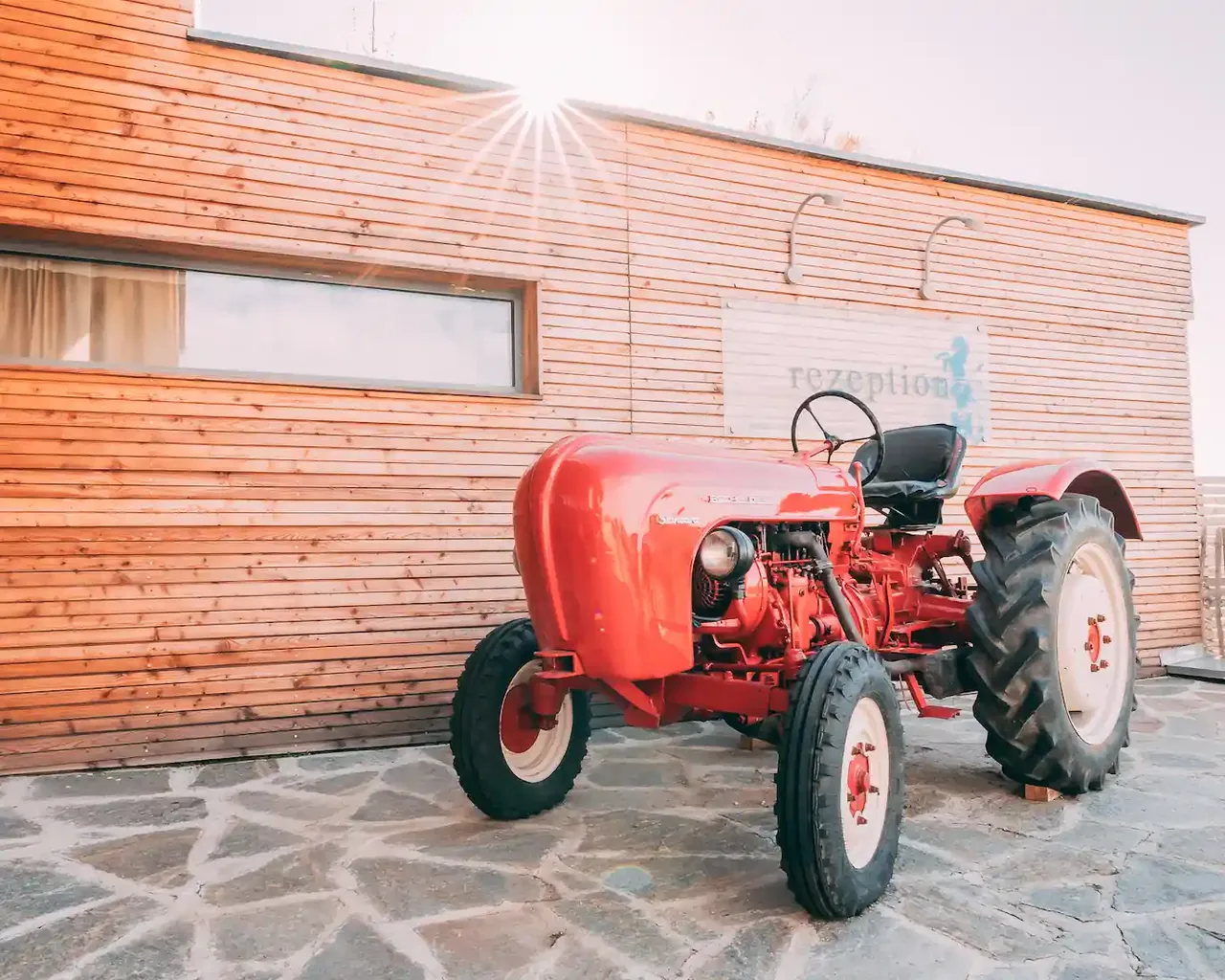 Roter Traktor vor der Rezeption von Gut Hügle